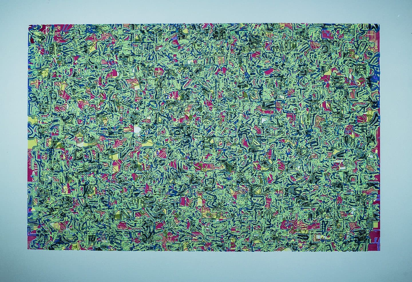 A green wall with many different colored plants.